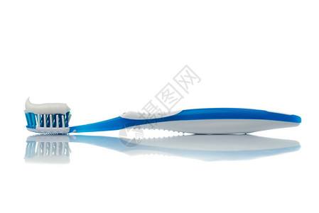 白色背景上有牙膏的蓝色牙刷图片
