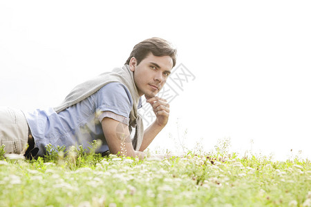 年轻男人躺在草地上的青草上图片