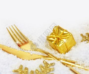 圣诞金色餐具和雪地上的装饰品图片