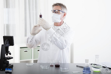 实验室或医院内从事注射显微镜和血液工作的科图片