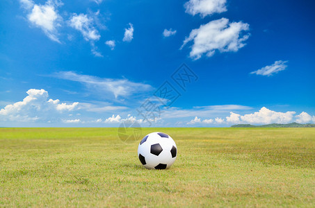蓝天下绿草地上的足球图片