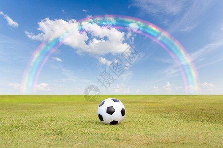 蓝天下绿草地上的足球图片