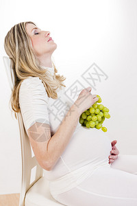 拿着一串葡萄的孕妇肖像图片