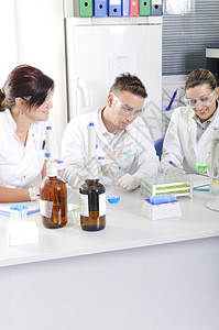 有吸引力的年轻博士生科学家在化学实验室观察溶液蒸馏后蓝色和绿色指示图片