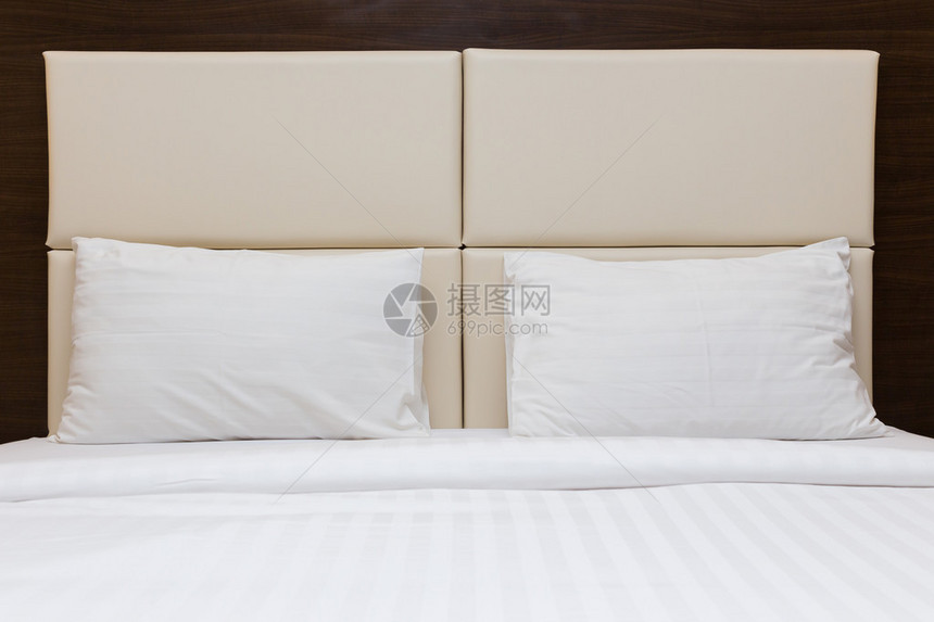 卧室里的白色枕头和皮革床头板图片