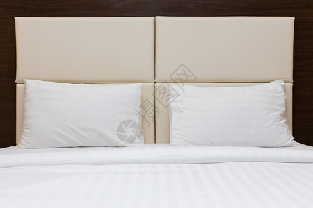 卧室里的白色枕头和皮革床头板背景图片