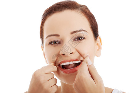 一个女人用牙线清洁牙齿的肖像图片