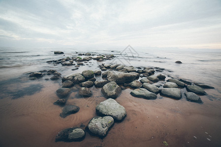 岩石海滩与海云的广角透视复古效果复古摄影效果复古颗粒状背景图片
