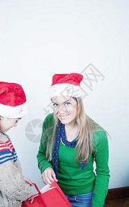 母亲和女儿在家拆开圣诞礼物假期概念图片
