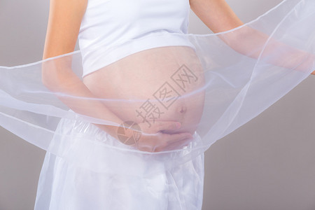 孕妇的腹部有灰色背景图片