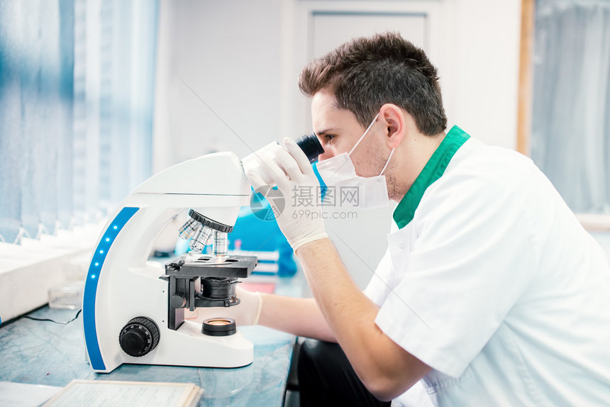 男科学家实验室中与显微镜图片