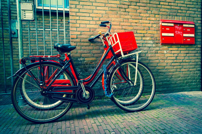传统的荷兰自行车停在阿姆斯特丹的砖墙附图片
