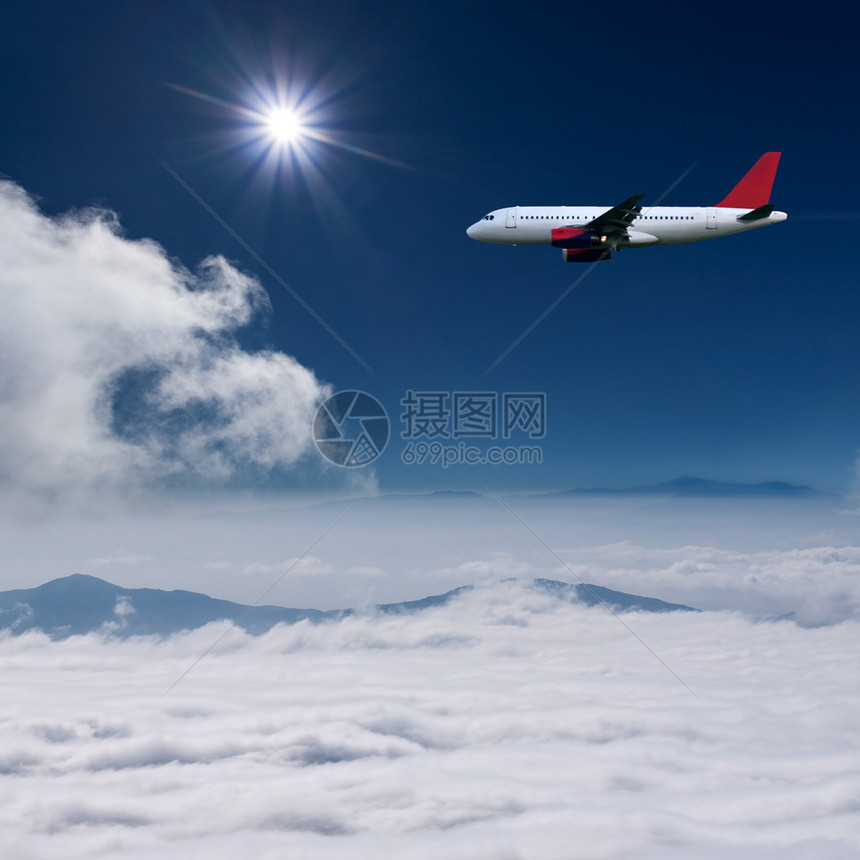 白色飞机高空飞越云层上空与太图片