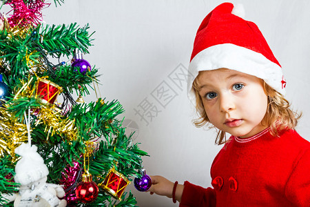 一个穿着圣诞老人帽子的可爱小女孩的肖像图片
