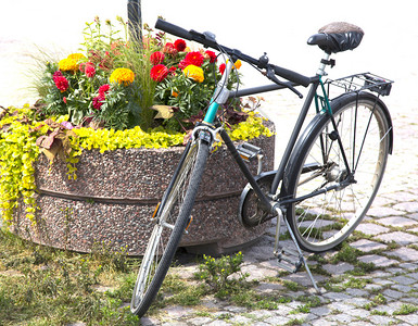 自行车站在人行道上的花坛上图片