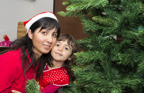 与母亲在家享受圣诞树的女婴家图片