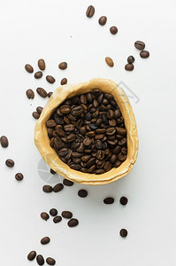 白色桌子上的乡村碗里的咖啡豆俯视图图片