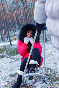 冬天森林里坐在雪橇上的女孩图片