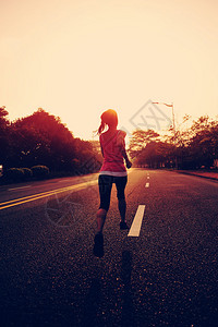 跑在路上的赛车运动员女健身日出慢跑锻背景图片