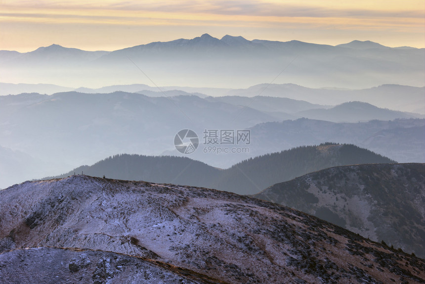 雾中许多山丘背景深处高山脉图片