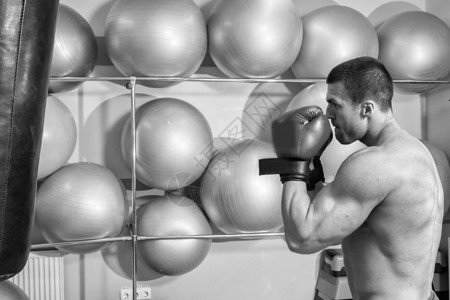 身穿拳击手套的肌肉男在健身房打中图片