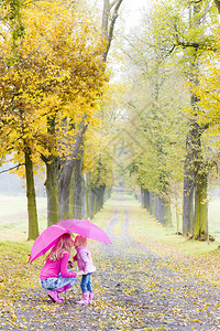 在秋巷带雨伞的妈和女儿图片