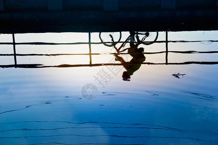 骑自行车的人硅酸盐和水面上的倒影图片