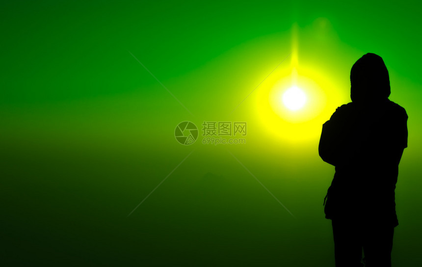 站在五颜六色的阳光背景上的剪影人图片