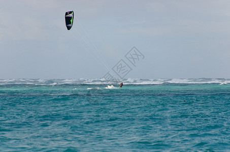 风筝冲浪在天空下的波浪中图片