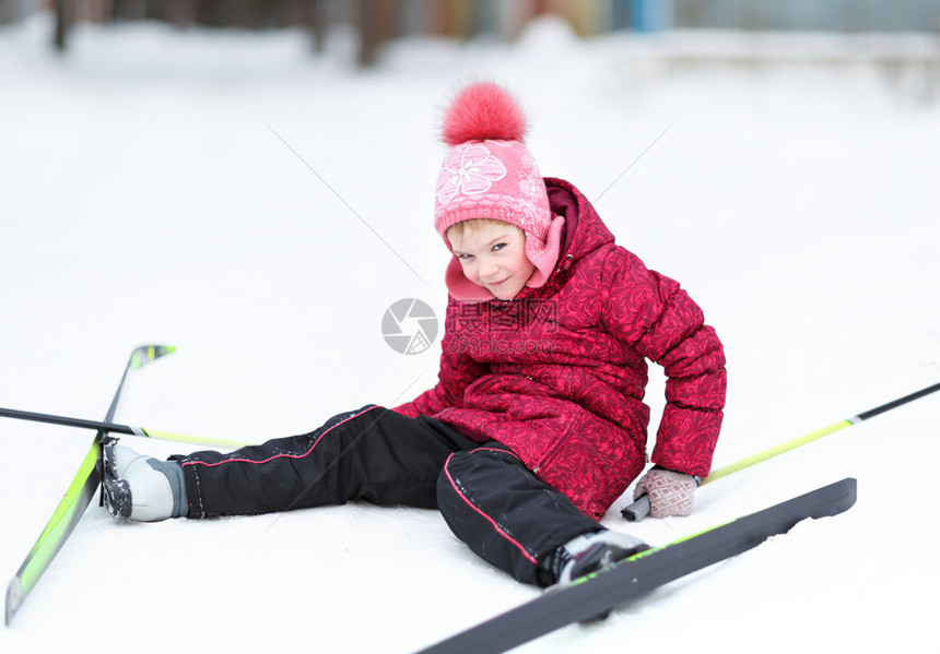 贝坐在雪地里穿冬季滑雪服图片