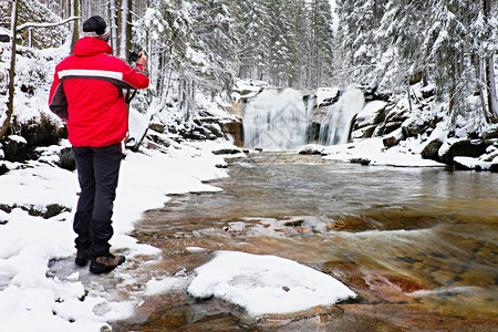 红色夹克照片与数码相机放在手中的数字照相机拍下冬图片