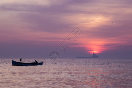 日出前的小船和货船图片