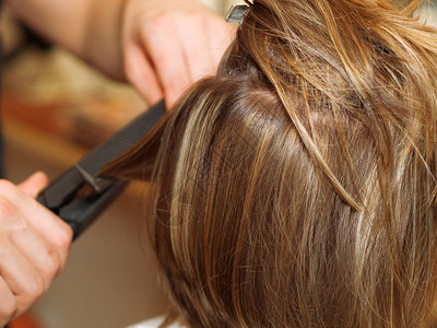 在美发工作室吹干头发的女人图片
