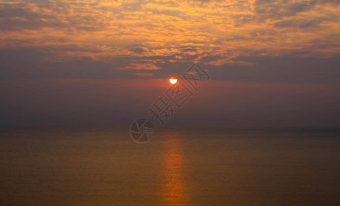 太阳从海面上升起带着金色的光芒图片