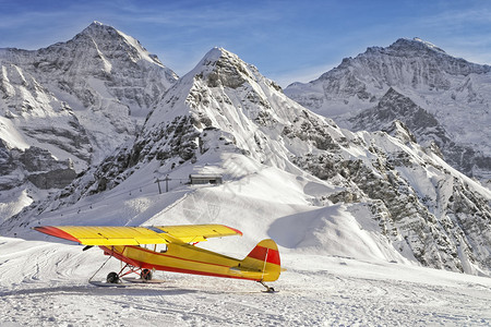 瑞士阿尔卑斯山机场的黄色红飞机图片