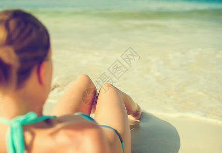 在海边晒日光浴的年轻女人图片