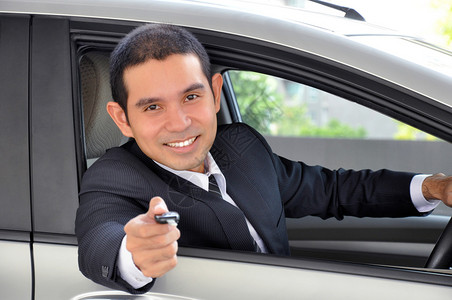 亚洲商人作为司机给车钥匙汽车销售和图片