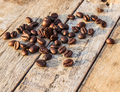 早晨阳光下木桌上的咖啡豆图片