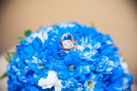 结婚戒指躺在一束蓝白图片
