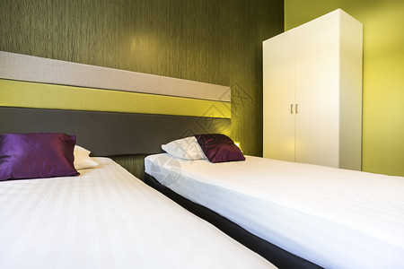 带两张单人床的绿色酒店房间图片