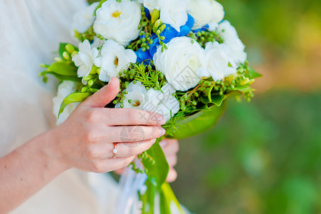 新娘带着戒指拿着一束蓝色花图片