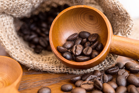 咖啡袋里的咖啡豆是木质表面的薄饼制成的聚图片