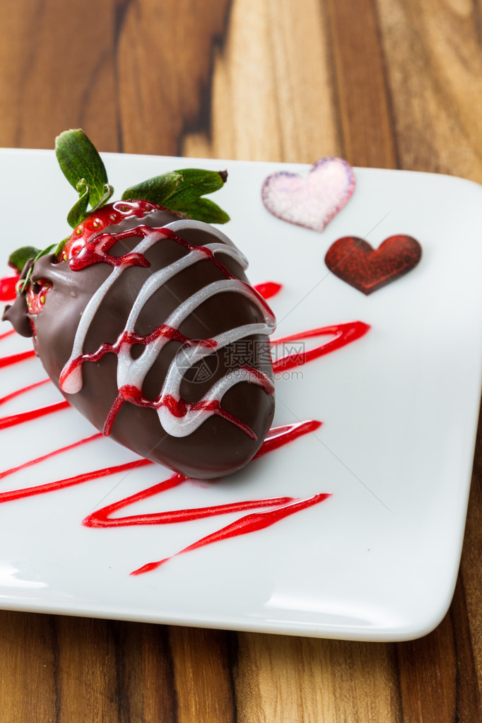 巧克力在白盘上盖着草莓有红色和白图片