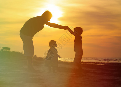 父亲和儿子在日落海滩为小图片
