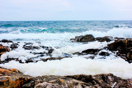 在寒风夏日在索佐波勒附近海滩的岩石上冲图片