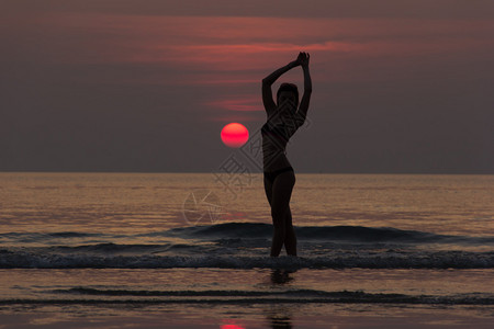 女孩在海面日落前海图片