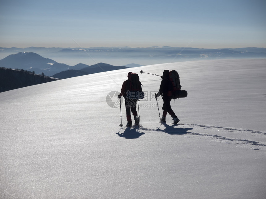 穿着雪鞋和登山杖的人进入山区图片