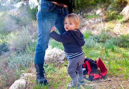 婴儿男孩抱着母亲的双腿图片