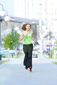 夏季清晨在城市街头公园跑步的女跑步者图片
