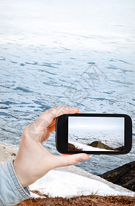 旅游概念游客在移动设备上拍摄白令海图片
